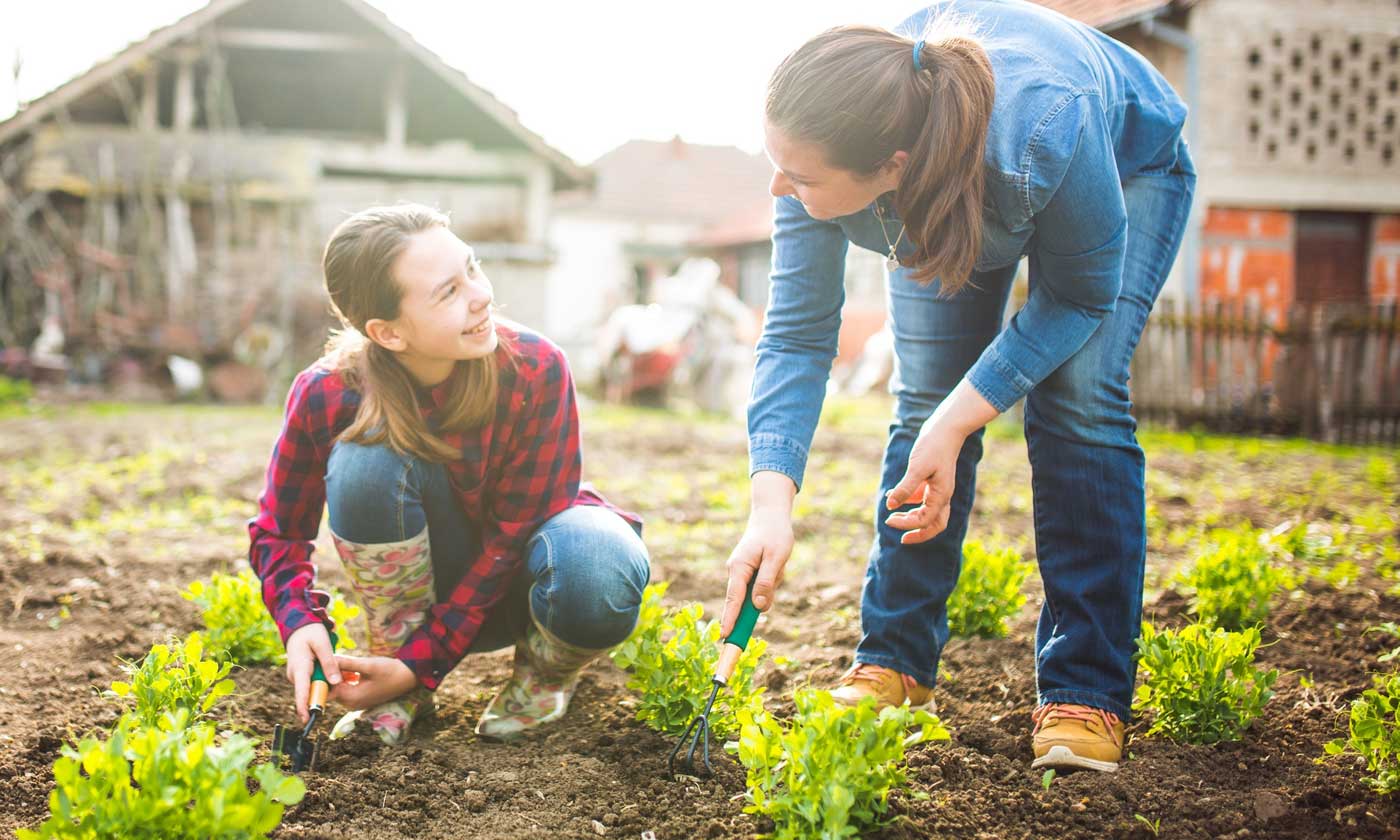 Mother and daughter working together in garden